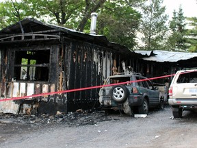 The remains of a mobile-home in Millhaven after a Kingston man allegedly lit it on fire with three people inside. OPP have charged him with attempted murder in Napanee, Ont. on Saturday May 30, 2015. Steph Crosier/Kingston Whig-Standard/Postmedia Network