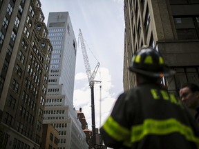 New York Fire Department members attend an emergency response after the cable of the crane snapped on a building in Manhattan, New York May 31, 2015. REUTERS/Eduardo Munoz