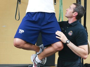 Tim Finlay (R), a fitness co-ordinator with the Toronto Police, helps coach Const. Jaime Shepherd on Friday, May 29, 2015. (Veronica Henri/Toronto Sun)