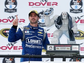 Jimmie Johnson poses with the Miles the Monster trophy after winning the NASCAR Sprint Cup Series FedEx 400 at Dover International Speedway on Sunday. (Getty Images/AFP)