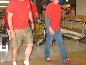 Paul Dawson, left, and Bill Merritt begin the Walk a Mile in Her Shoes march after stepping off the escalator at the Downtown Chatham Centre on Sunday. Heavy rain caused the organizers to move the event indoors.
(Blair Andrews/Chatham This Week)