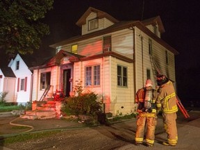 Sarnia firefighters tend to the scene of a triplex fire near the intersection of College Avenue and Wellington Street early Saturday morning. (Photo by TROY SHANTZ)
