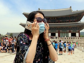 A Chinese tourist wearing a mask to prevent contracting Middle East Respiratory Syndrome (MERS) tours the Gyeongbok Palace in Seoul, South Korea, June 1, 2015. (REUTERS/Choi Jae-gu/Yonhap)