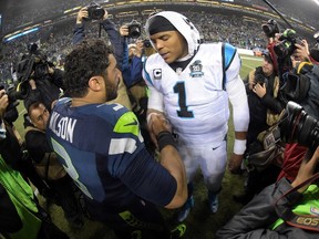 Seattle Seahawks quarterback Russell Wilson (3) meets with Carolina Panthers quarterback Cam Newton (1) following the 31-17 victory in the 2014 NFC Divisional playoff football game at CenturyLink Field. (Kirby Lee-USA TODAY Sports)