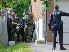 York Regional Police were forced to shoot a black bear that had been spotted in Newmarket, Ont., for several days. The dead bear is removed from the backyard of a home on Monday June 1, 2015. (Dave Thomas/Postmedia Network)