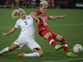Canada's Sophie Schmidt (right) battles for the ball against England's Steph Houghton during exhibition action in Hamilton, Ont., on Friday, May 29, 2015. Canada opens the Women's World Cup in Edmonton on Saturday against China. (Craig Robertson/Postmedia Network)