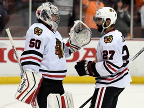 Chicago Blackhawks goalie Corey Crawford (50) and defenceman Johnny Oduya (27) celebrate the 5-3 victory against the Anaheim Ducks following game seven of the Western Conference Final of the 2015 Stanley Cup Playoffs at Honda Center May 30, 2015. (Gary A. Vasquez-USA TODAY Sports)