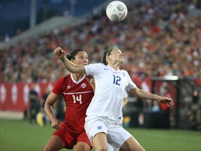 Lucy Bronze #12 of England tries to head the ball as Melissa Tancredi #14 of Canada applies pressure during their Women's International Friendly match on May 29, 2015 at Tim Hortons Field in Hamilton, Ontario, Canada. (Tom Szczerbowski/Getty Images/AFP)
