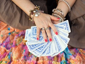A fortune-teller displays a deck of cards. (Fotolia)