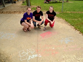 Dani Schoonderwoerd (left), Zach Misener and Kelsey Ramseyer of the Stratford-based THINK team were at Fastballfest in Mitchell May 30 to raise awareness of the dangers of chewing tobacco. Above, the THINK team poses with their 91 Reasons Not to Smoke display, where kids had the chance to write, in chalk, why they choose not to smoke or use tobacco products. GALEN SIMMONS/MITCHELL ADVOCATE