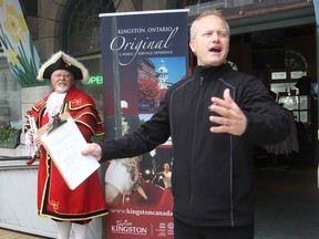 With a flourish, Tourism Kingston director Rob Carnegie announces the kickoff to Tourism Awareness Week in Kingston on Monday. At left is town crier Chris Whyman. (Michael Lea/The Whig-Standard)