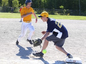 Sebastien Larochelle of College Notre Dame is safe at third base as Brady Maltais of Bishop Cater misses a catch during high school boys slow pitch championship game action in Sudbury, Ont. on Monday June 1, 2015.