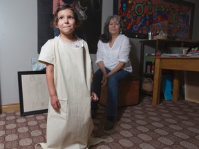 Four-year-old Naackepiinwinga Payer wears a dress created by her artist grandmother Nancy Deleary in Chippewas Of The Thames, Ont. on Monday June 1, 2015.  Deleary modelled the design on dresses that her grandmothers would have worn during their time at the Mount Elgin residential school. (DEREK RUTTAN, The London Free Press)