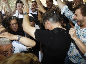 Spanish chefs of "El Celler de Can Roca" Joan Roca (C) and Jordi Roca celebrate the award of world's best restaurant with employees at their restaurant in Girona on June 2, 2015. Spain's "El Celler de Can Roca" was crowned the world's best restaurant on June 1, 2015. AFP PHOTO/ QUIQUE GARCIA