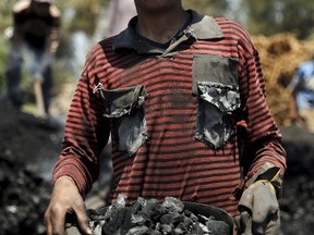 Saied Ashraf,15, poses for a photo at a traditional charcoal factory at a village in Qaha, El-Kalubia governorate, near Cairo, May 7, 2015. Each labourer works approximately 10 hours and earns a daily wage of 70 Egyptian pounds ($9) per day. Last year Egypt approved expanded industrial coal use to help it confront its worst energy crisis in decades. But acknowledging environmental concerns, it says it has also tightened enforcement of regulations related to local coal burning and domestic charcoal production. Picture taken May 7, 2015. REUTERS/Amr Abdallah Dalsh