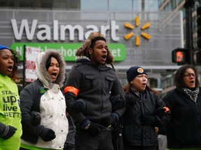 Protesters outside a Wal-Mart store link arms in the street before being removed by police during a demonstration for higher wages and better working conditions in Chicago, in this file photo taken November 28, 2014. (REUTERS/Andrew Nelles/Files)