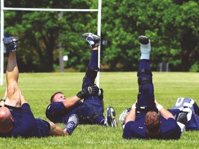 Some Argos players stretch after training camp at York University on Wednesday. (DAVE ABEL/Toronto Sun)