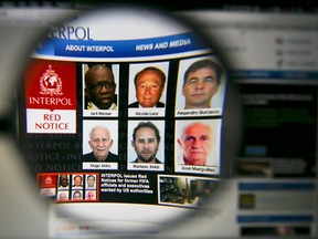 The homepage of the Interpol website is seen through a magnifying glass in this picture illustration taken in Berlin, Germany on June 3, 2015. Interpol said on Wednesday it has issued international wanted-person alerts for two former FIFA officials including Jack Warner and four corporate executives at the request of U.S. authorities as part of a corruption probe. (REUTERS/Pawel Kopczynski)