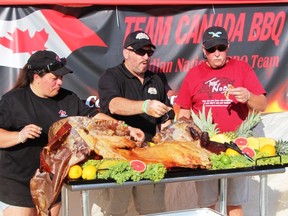 Barb VanRassell of Team Canada BBQ, Cochrane Mayor Peter Politis, and Bill Pudim, organizer of Smoke on the Water competition check out some of the tasty offerings.