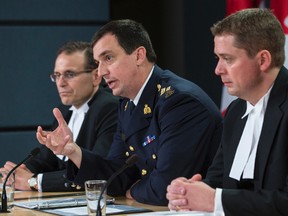 RCMP Assistant-Commissioner Gilles Michaud (centre) speaks as Senate Speaker Leo Housakos (L) and House of Commons Speaker Andrew Scheer (R) listen during a press conference regarding the release of four reports into the Oct. 22 attack on Parliament Hill. June 3, 2015. Errol McGihon/Postmedia Network