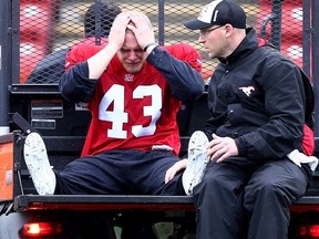 Calgary Stampeders linebacker Max Caron, a Kingston native, reacts after being loaded onto a cart after hurting his left Achilles tendon at the CFL team’s training camp on Wednesday. Caron missed all of last season after tearing his right Achilles tendon. Later in the day Caron tweeted “You can’t control everything in life. Bad things happen. What you can do is choose how you wish to respond.” (Darren Makowichuk/Postmedia Network)