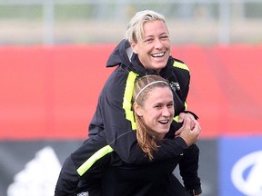 Team USA women's soccer player Abby Wambach gets a piggy-back ride from Heather O'Reilly during practice for the FIFA Women's World Cup  in Winnipeg, Man. Wednesday June 03, 2015.