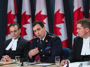 RCMP Assistant-Commissioner Gilles Michaud (centre) speaks as Senate Speaker Leo Housakos (L) and House of Commons Speaker Andrew Scheer (R) listen during a press conference regarding the release of four reports into the Oct. 22 attack on Parliament Hill. June 3, 2015. Errol McGihon/Postmedia Network