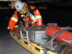 Postmedia file photo
A mine rescue volunteer from Glencore Kidd Operations (Timmins) guides a stretcher loaded with equipment underneath a conveyor belt at a mine rescue competition.