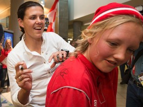 Christine Sinclair signs autographs as members of Team Canada arrive at the Edmonton International Airport on June 2, 2015. (David Bloom/Postmedia Network)