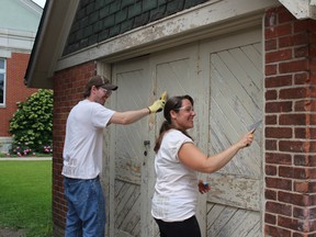 It's all fun and games for Kerry employees Rocki Luce (left) and Stephanie Quast, who scraped and painted at the Oxford United Way during Day of Caring. (MEGAN STACEY/Sentinel-Review file photo)