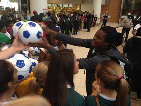 Iniabasi Umotong signs a ball for one of the many Nigerian supporters who showed up at the airport on Thursday. Winnipeg hosting an event as big as the Women's World Cup means a chance to show off for the many fans who come in from out of province and out of country. (David Larkins/Winnipeg Sun/Postmedia Network)