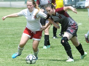 Wallaceburg Tartans' Kaitlyn Quinlan, right, and Bayside Red Devils' Christine Lynch battle for the ball in the second half Thursday at the OFSAA 'AA' girls soccer championship in Wallaceburg. (MARK MALONE/The Daily News)