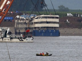 A rescue team works on lifting the capsized cruise ship Eastern Star in the Jianli section of Yangtze River, Hubei province, China, June 5, 2015. The death toll from the Chinese cruise ship that capsized on the Yangtze River climbed to 97 on Friday as authorities righted the battered vessel and turned their efforts to recovering bodies still on board amid simmering anger from distraught families. REUTERS/Kim Kyung-Hoon