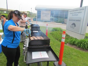 Vicky Praill of Tourism Sarnia Lambton mans a grill on Friday June 5, 2015 in Point Edward, Ont., during a free barbecue held to celebration national Tourism Week. (Paul Morden/Sarnia Observer/Postmedia Network)