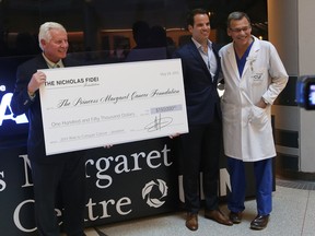 Paul Alofs (left) and Dr. Jonathan Irish (right) receive a cheque from Nicholas Fidei (centre).
