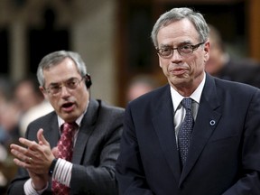 Canada's Finance Minister Joe Oliver (R) is applauded by Treasury Board President Tony Clement while standing to speak during Question Period in the House of Commons on Parliament Hill in Ottawa May 26, 2015. REUTERS/Chris Wattie