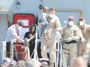 Belgian sailors help migrant children and women off the Godetia logistical support ship of the Belgian Navy last week upon its arrival in the port of Crotone in the Italian southern region of Calabria, as part of Frontex-co-ordinated Operation Triton off the Italian coast.  (ALFONSO DI VINCENZO/AFP photo)