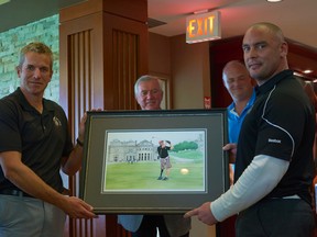 Master Cpl. Etienne Aube (right) receives a print from Maj. Jay Feyko of a painting made of him inspired by his trip to St. Andrews last year. (DAN MATTHEWS/PHOTO)