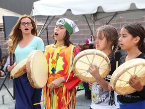Owyn Assinewai, second left, Kierrah Lefebvre and Jade Sauve-Gadabushie, of the Princess Anne Ojibway Language Hand Drummers and Singers, perform at a powwow held at Princess Anne Public School in Sudbury, Ont. on Friday June 5, 2015. John Lappa/Sudbury Star/Postmedia Network