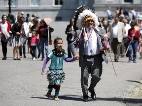 Assembly of First Nations National Chief Perry Bellegarde runs with a school girl to place a heart shaped card in the Heart Garden, which is meant to symbolize reconciliation, during the Truth and Reconciliation Commission of Canada closing ceremony at Rideau Hall in Ottawa June 3, 2015.    REUTERS/Blair Gable