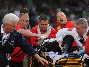 A fan is attended to by medical staff after being hit by a broken bat during a game between the Boston Red Sox and the Oakland Athletics at Fenway Park on June 5, 2015 in Boston. (Jim Rogash/Getty Images/AFP)