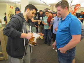 Charles Asselin of Beau's Brewery pours a sample for Andrew Pryor on Saturday June 6, 2015 in Sarnia, Ont., during the Beer Show at the Bayside Centre, downtown. It was the third year for the annual craft beer showcase. Paul Morden/Sarnia Observer/Postmedia Network