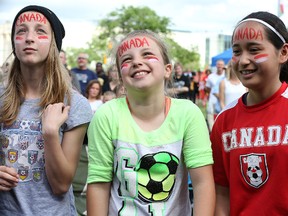 Young girls react during the national anthem as Canada took on China on the big screen during the kickoff to FIFA Women's World Cup Canada 2015 in the fan zone at Winnipeg Stadium on Sat., June 6, 2015. (Kevin King/Winnipeg Sun/Postmedia Network)