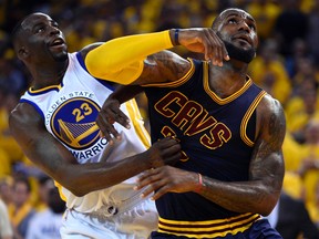 Warriors’ Draymond Green (left) and Cavaliers’ LeBron James fight for a rebound during Game 1.  (USA TODAY SPORTS/PHOTO)