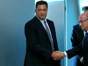 Sepp Blatter (R) shakes hand with Domenico Scala, chairman of the FIFA's audit and compliance committee, after his statement during a news conference at the FIFA headquarters in Zurich, Switzerland, June 2, 2015.   REUTERS/Ruben Sprich