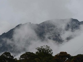 Malaysia's Mount Kinabalu is seen among mists from the Timpohon gate check point a day after the earthquake in Kundasang, a town in the district of Ranau on June 6, 2015.  (AFP PHOTO/MOHD RASFAN)