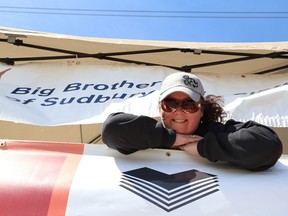 Chantal Gladu, executive director of Big Brothers Big Sisters of Greater Sudbury, looks down from a makeshift castle while participating in the Great Coke Castle Rescue at the New Sudbury Centre in Sudbury, Ont. on Saturday June 6, 2015. Gladu had to stay on top of the structure until 700 cases of Coke were sold. All proceeds from the event will go to the organization. John Lappa/Sudbury Star/Postmedia Network
