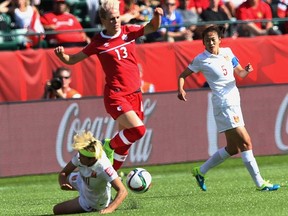 Canada's Sophie Schmidt jumps over a China player during FIFA Women''s World Cup at Commonwealth Stadium in Edmonton on Saturday June 5, 2015. (Perry Mah/Postmedia Network)