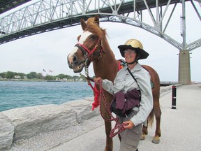 Megan Lewis, from Wales, and her pony, Lady, stopped beneath the Blue Water Bridge  Sunday June 7, 2015 in Point Edward, Ont. during their multi-year trip across North America. They were set to cross Monday into Michigan as the journey continued west. Paul Morden/Sarnia Observer/Postmedia Network