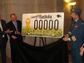 Manitoba Justice Minister Gord Mackintosh, left, and others unveil a new 'Support Our Troops' licence plate to honour Canadian Armed Forces. (Jim Bender/Winnipeg Sun)